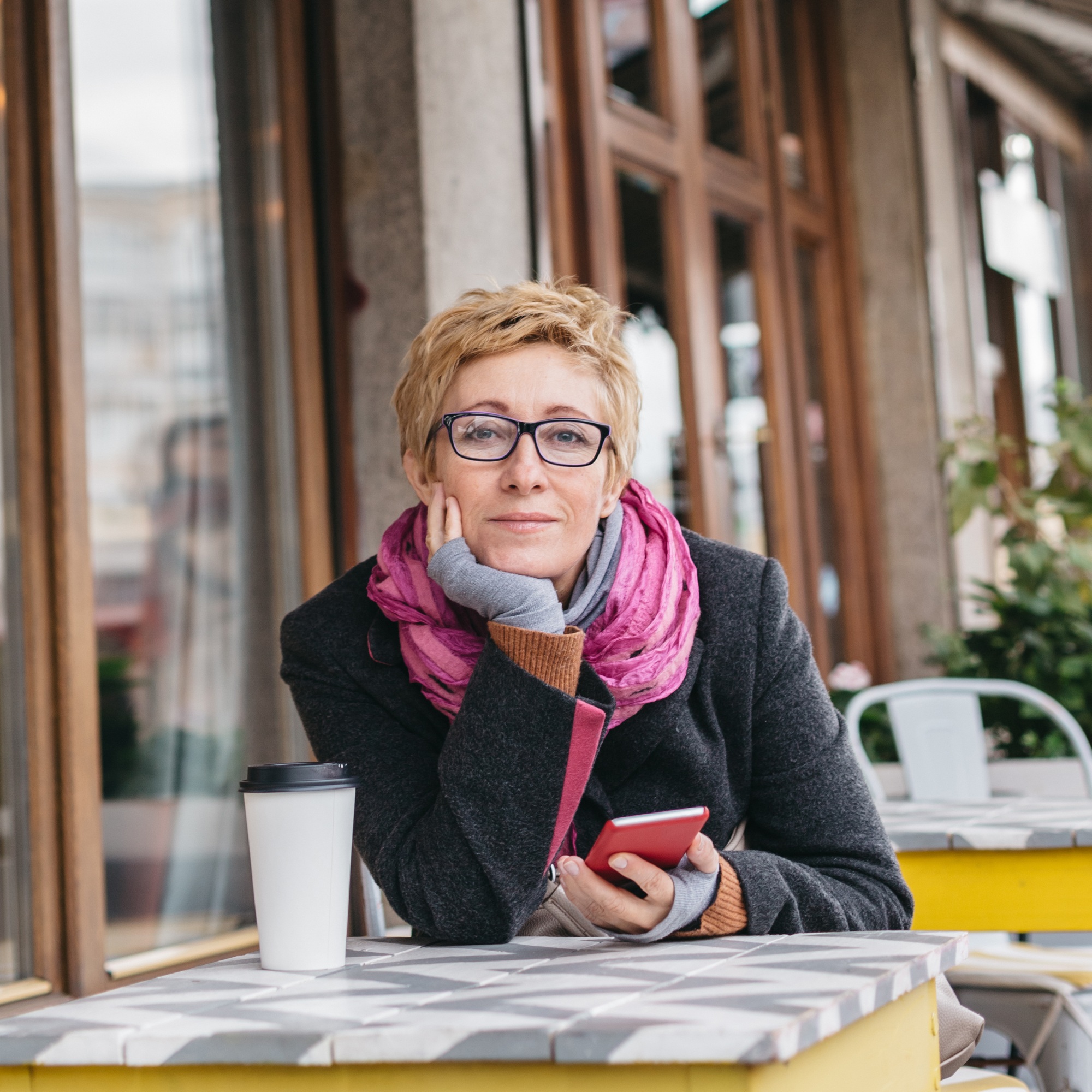 Dreamy woman with phone in cafe